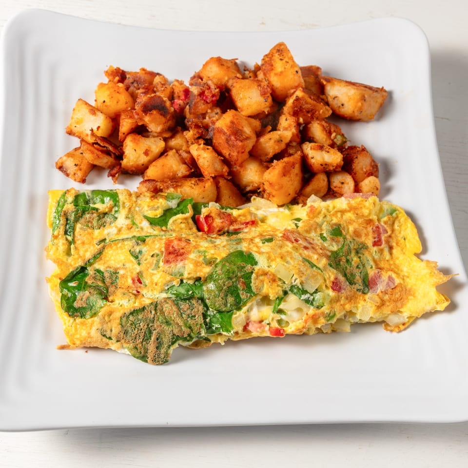 A Pierce Street Bagel Cafe Deli & Grill omelet with spinach and peppers, served with seasoned home fries.