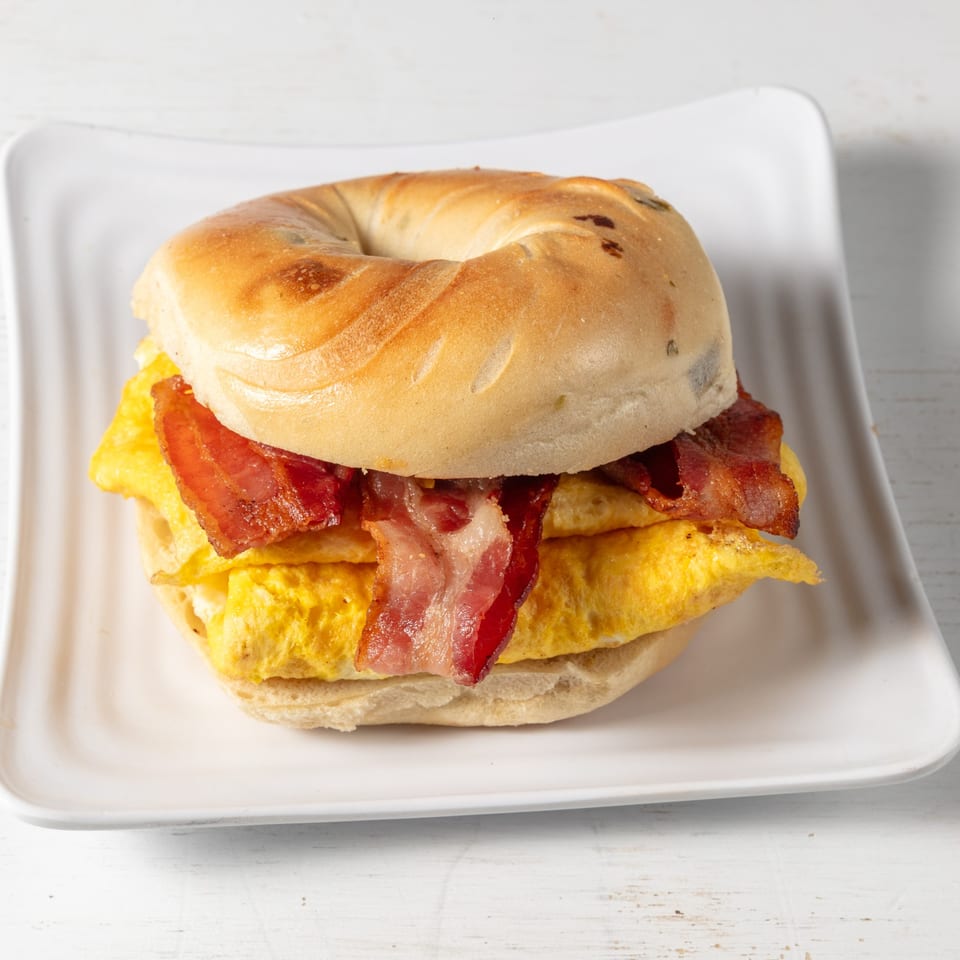 Pierce Street Bagel Cafe Deli & Grill's bacon, egg, and cheese bagel sandwich on a white plate.
